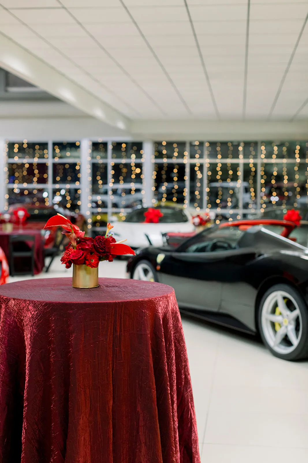 Ferrari of Denver holiday event with deep red floral centerpiece