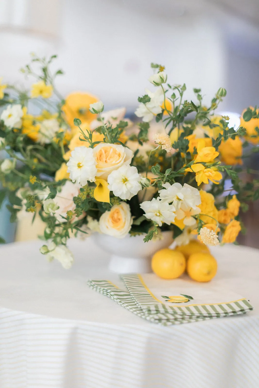 Butter yellow and lemon floral arrangement on Sorento Sunkiss linens
