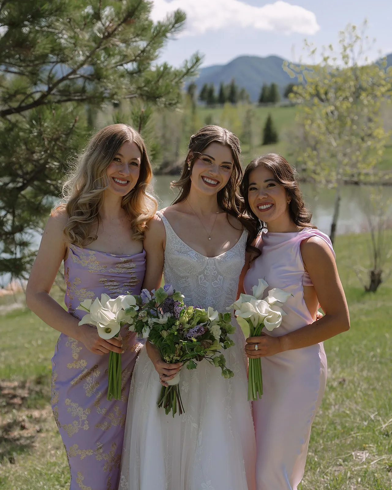 Bride and bridesmaids in lavender dresses with mountain backdrop