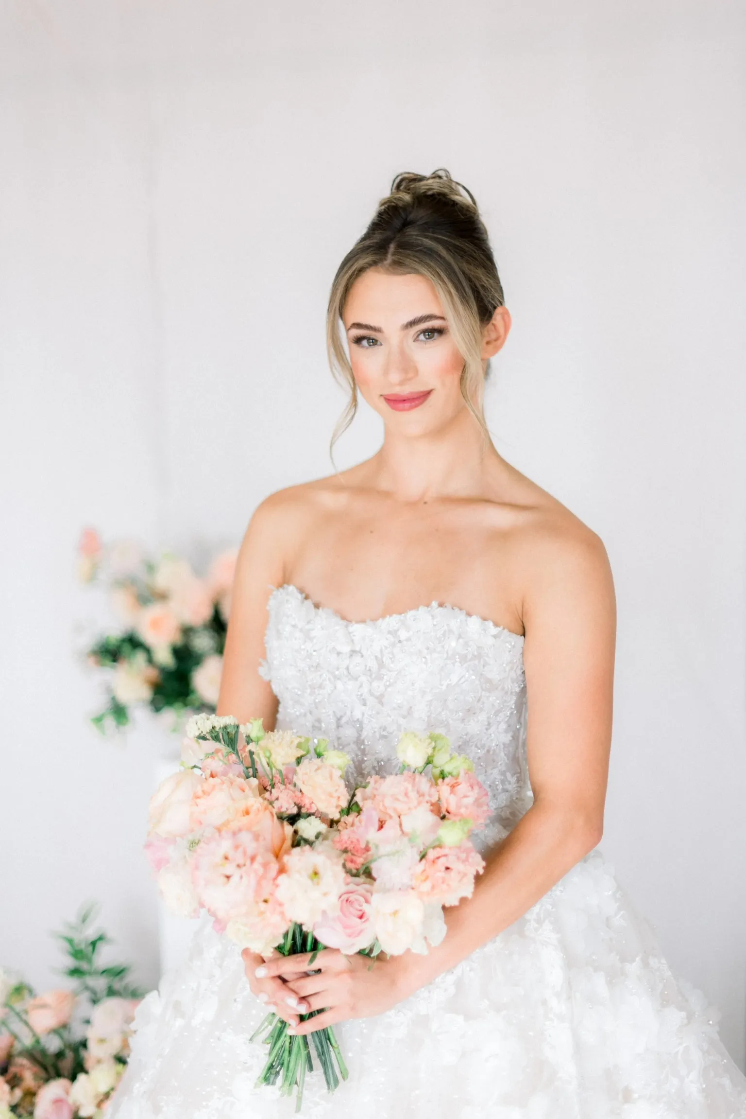 Bride holding a pink and white bouquet indoors