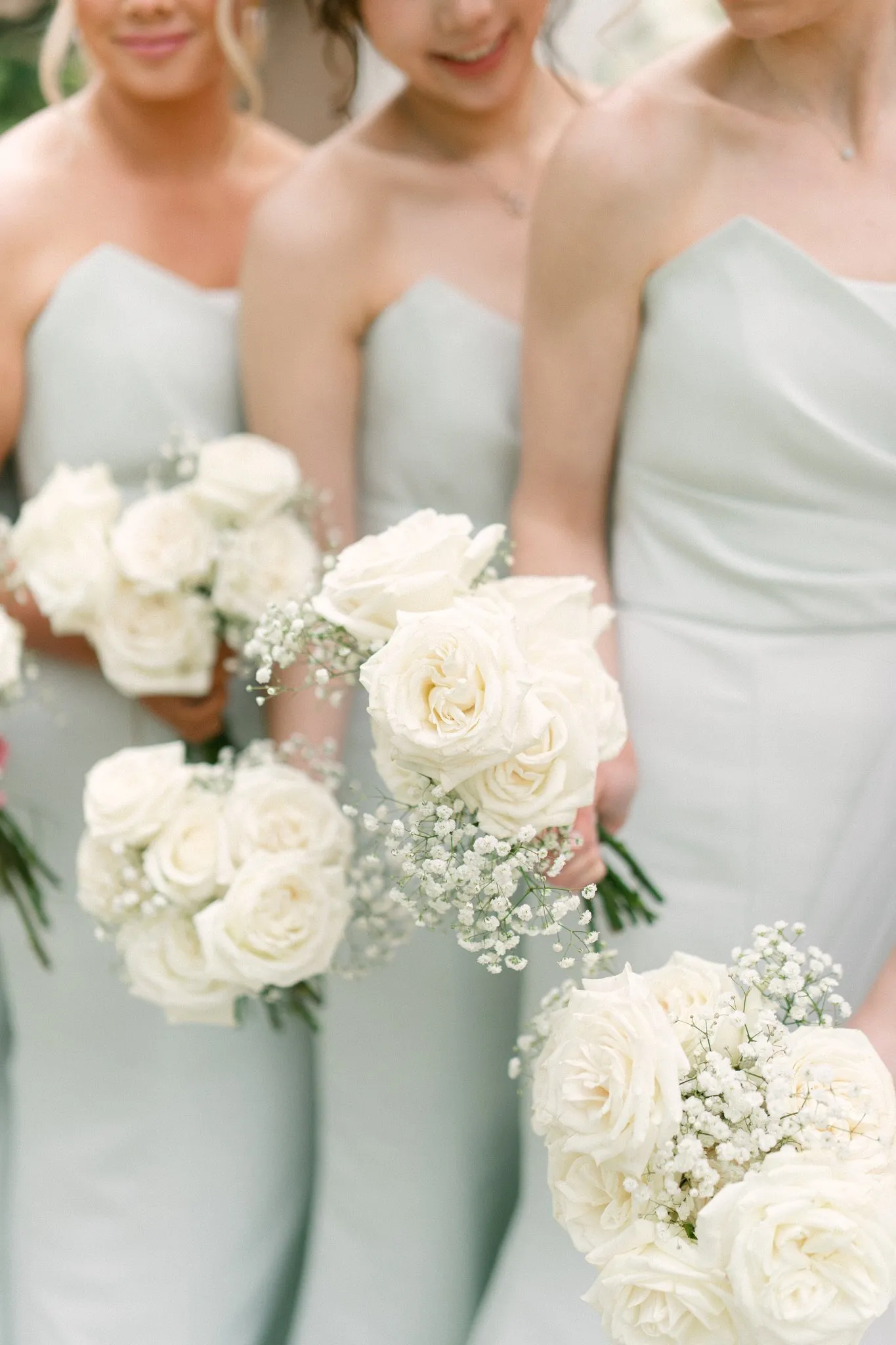 Bridesmaids holding white rose bouquets at wedding