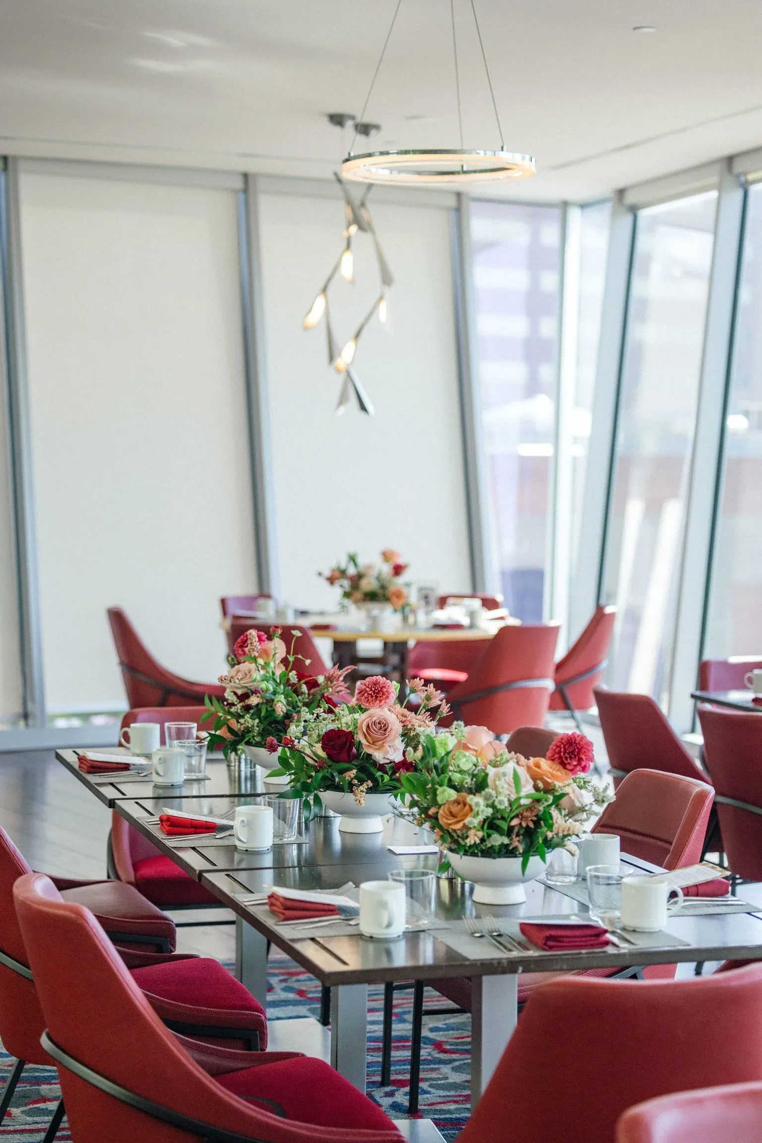 Corporate dining table with red napkins and white floral centerpieces